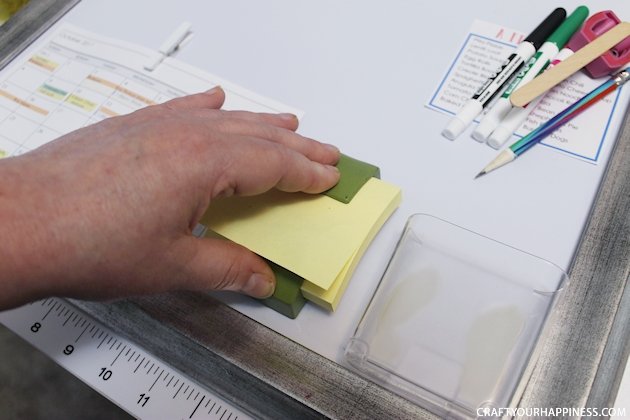 It's super easy to make any size DIY dry erase board using a roll of adhesive backed dry erase paper. We made a kitchen board and added some extras including making our own eraser!