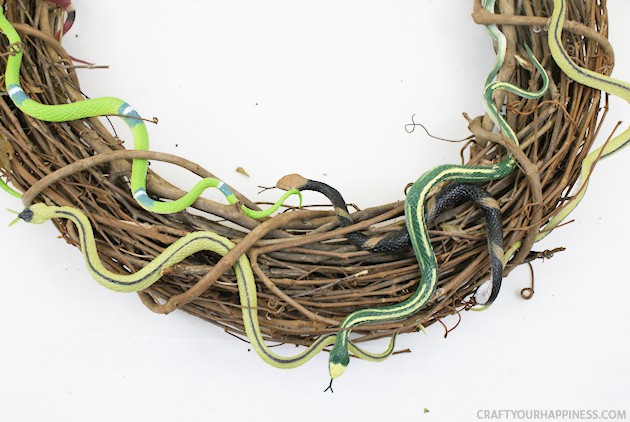 Make this creepy crawly DIY Halloween wreath to frighten up your door! It's cheap & quick to make. Use any bugs you like, but we choose spiders & snakes.