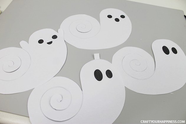 Need quick Halloween decorations? Grab our printables, some scissors or X-acto knife and before you know it you have have a room full of dangling ghosts!