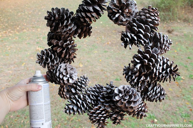 Learn how to make a pinecone wreath in 30 minutes! You can decorate the base wreath however you wish. We used a big red bow. Plus it's an upcycle project!