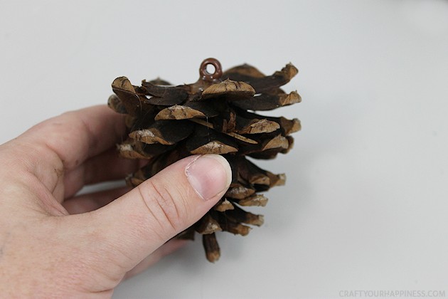 Learn how to make a pinecone wreath in 30 minutes! You can decorate the base wreath however you wish. We used a big red bow. Plus it's an upcycle project!