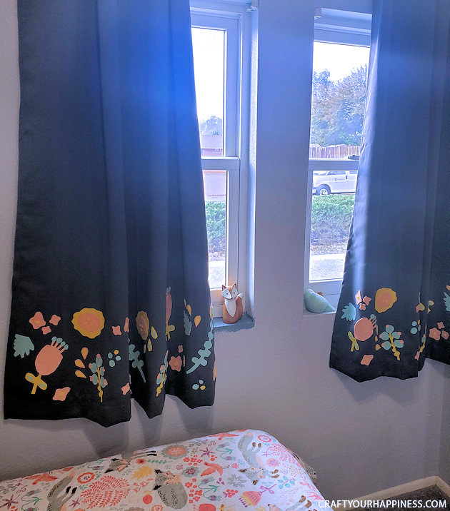 Blackout curtains are great if you sleep best in a dark room. However, room darkening curtains tend to be bland. Not any more! We’ll show you how to do a simple charming and inexpensive blackout curtain makeover using some felt and fabric glue! Free pattern included!