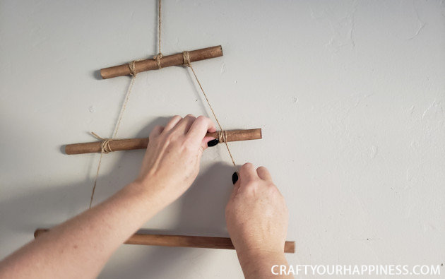 This easy DIY hanging wall Christmas tree made from dowels (or branches) is perfect if you're on a budget or you have very little space for a normal tree. 