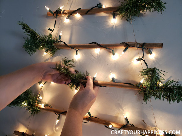 This easy DIY hanging wall Christmas tree made from dowels (or branches) is perfect if you're on a budget or you have very little space for a normal tree. 