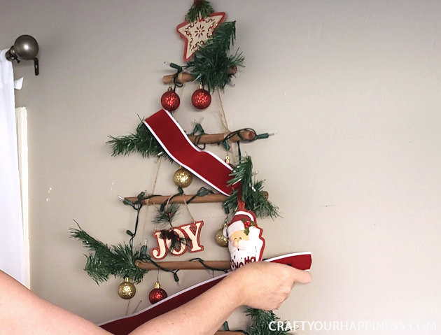 This easy DIY hanging wall Christmas tree made from dowels (or branches) is perfect if you're on a budget or you have very little space for a normal tree. 