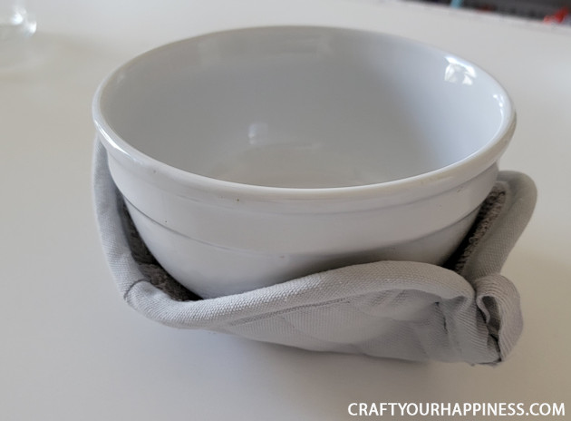 Make a DIY bowl cozy using a $2 hot pad! No more burned fingers trying to get a hot bowl out of the microwave. (No sewing machine needed!)