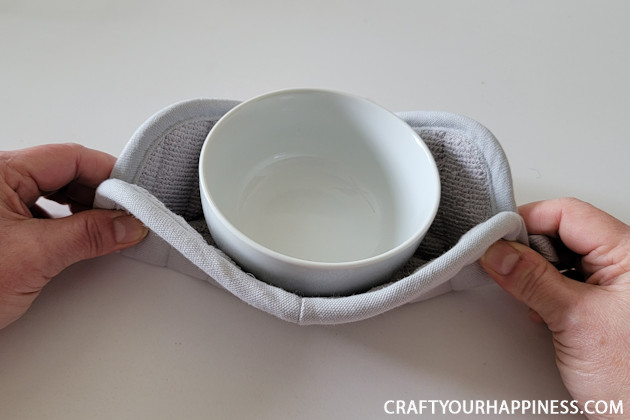 Make a DIY bowl cozy using a $2 hot pad! No more burned fingers trying to get a hot bowl out of the microwave. (No sewing machine needed!)