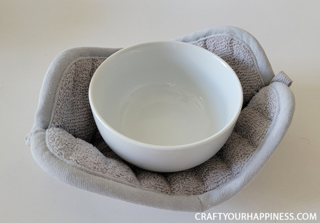 Make a DIY bowl cozy using a $2 hot pad! No more burned fingers trying to get a hot bowl out of the microwave. (No sewing machine needed!)